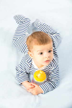the baby drinking milk from the bottleの写真素材