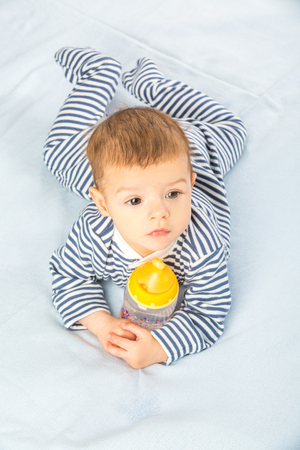 the baby drinking milk from the bottleの写真素材