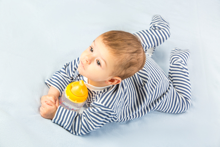the baby drinking milk from the bottleの写真素材