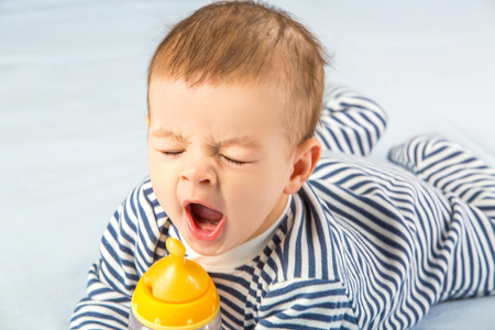 the baby drinking milk from the bottleの写真素材