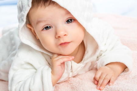 the beautiful little baby, lie  on stomach  on towelの写真素材