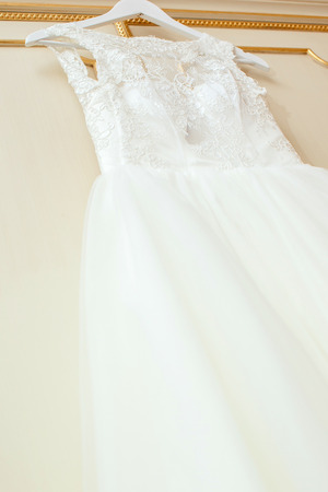 White Wedding dress hanging on a shoulders. Soft light and coloursの写真素材