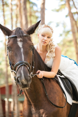 young beautiful bride and horse on the natureの写真素材