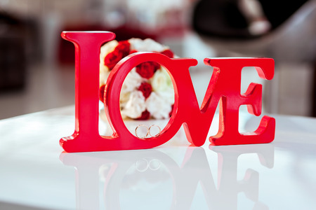 Closeup photo of Two wedding gold rings and bouquetの写真素材