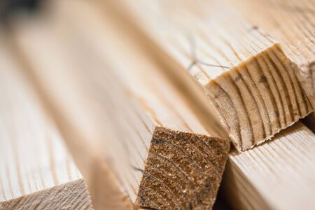 Wooden beams and planks. Lumber stacked at construction siteの写真素材