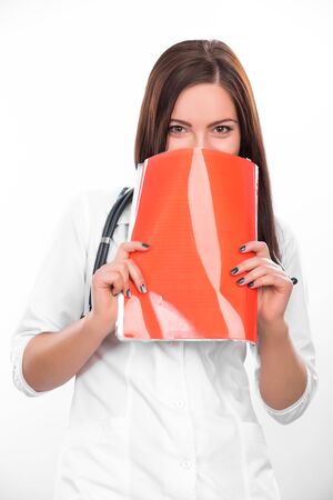 Female doctor with a folder and stethoscope thinkingの写真素材