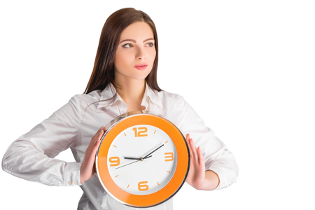 Portrait of beautiful young business woman holding in hands clock, isolated on white background, discipline and punctual conceptの写真素材