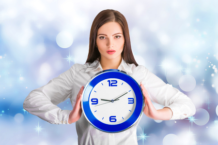 Portrait of beautiful young business woman holding in hands clock, discipline and punctual conceptの写真素材