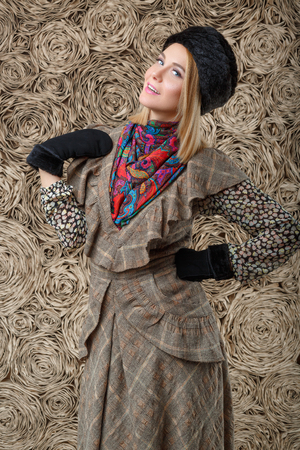 beautiful attractive blonde girl in a brown dress and black fur hatの写真素材
