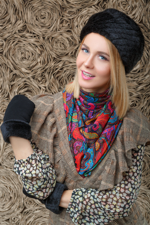 beautiful attractive blonde girl in a brown dress and black fur hatの写真素材