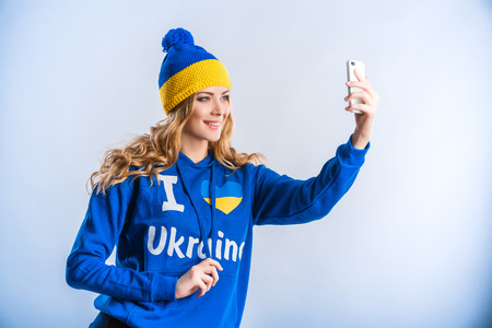 beautiful blonde woman in blue sports jacket makes a selfieの写真素材