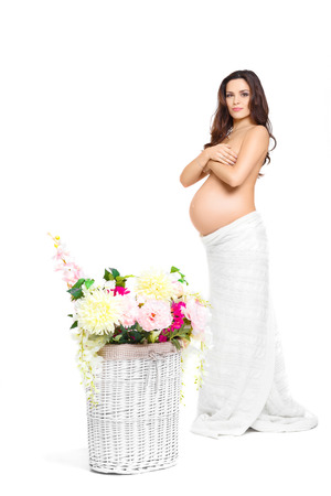 beautiful pregnant woman and a basket of colourful flowers.の写真素材