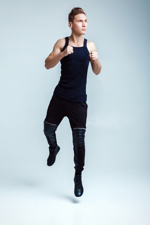 attractive young man fight on white background. the athlete jumps upの写真素材