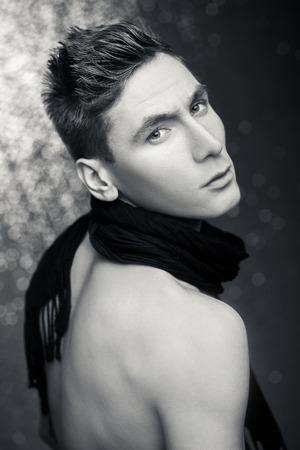 attractive young man with scarf on a silver background.  black and white photoの写真素材