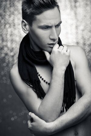attractive young man with scarf on a silver background.  black and white photoの写真素材