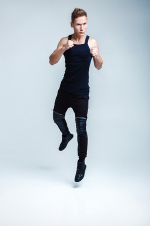 attractive young man fight on white background. the athlete jumps upの写真素材