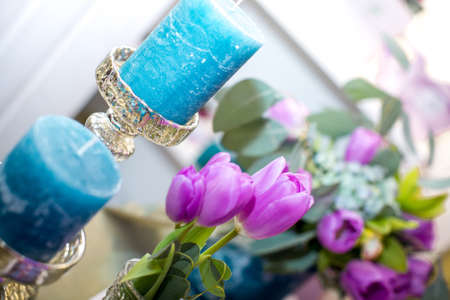 the blue candles and purple tulipsの写真素材