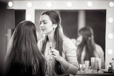 Makeup artist apply makeup to a model.