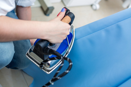 Tailor ironing the fabric. seamstress irons dress in a sewing workshopの写真素材
