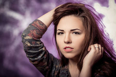 young beautiful girl with long hair on dark backgroundの写真素材