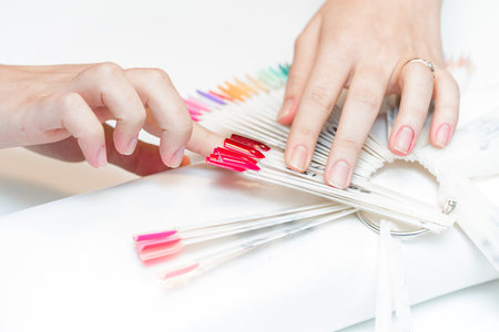 the girl chooses the color of Polish for manicure. testers nail Polishの写真素材