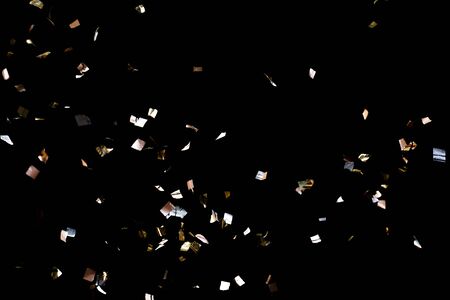 Golden confetti isolated on black backgroundの写真素材