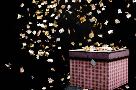 purple gift box and confetti. Black background. Gifts for Christmas.の写真素材
