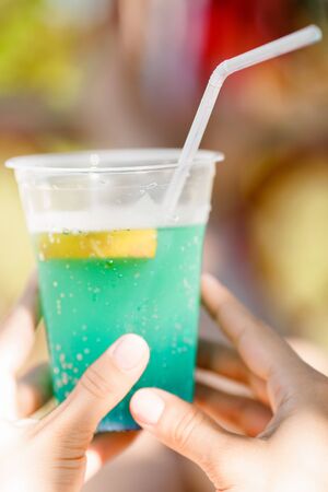 woman holding cocktail in the hammock