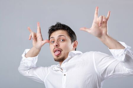portrait of young attractive man with dark hair in shirt fooling