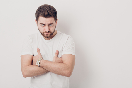 portrait of handsome young serious brunette man with beard in t-の写真素材