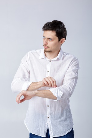 portrait of attractivebrunette man in white shirt adjusting hisの写真素材