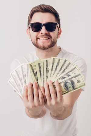 handsome smiling man with beard in shirt holding hundred-dollar