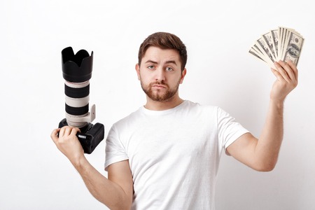 young handsome photographer with beard in shirt holding camera aの写真素材