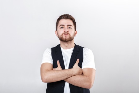 portrait of handsome young serious man in white shirt on gray backgroundの写真素材