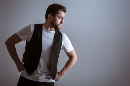 portrait of handsome young serious man in white shirt on gray backgroundの写真素材