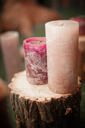 two large purple candles on wooden stumpの写真素材