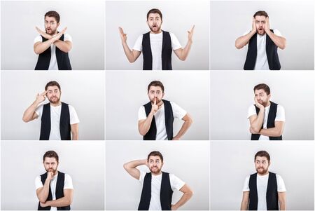 portrait of young attractive surprised brunette man in white shirt on gray background. surprising factの写真素材