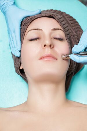 Beautician makes mechanical cleaning of face. Procedure of Microdermabrasion, diamond grinding.の写真素材