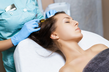 Needle mesotherapy. Cosmetic been injected in womans head. Thrust to strengthen hair and their growthの写真素材