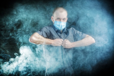 young doctor in a mask in smokeの写真素材