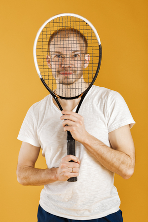 young tennis player plays tennis on yellow backgroundの写真素材