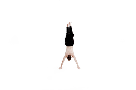 Young man doing yoga exercises. Studio shot on white background