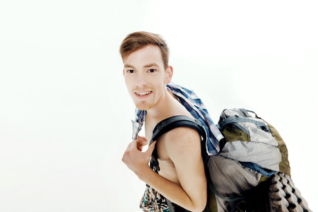 Funny portrait of young hiker with backpack on white backgroundの写真素材