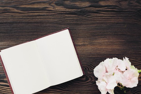 flat lay pink flowers and diary on wooden background, top view. mock upの写真素材