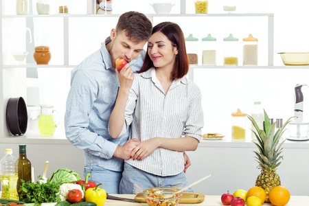 Loving happy couple eating  apple in kitchenの写真素材