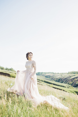 fine art wedding photography. Beautiful bride with bouquet and dress with train in natureの写真素材