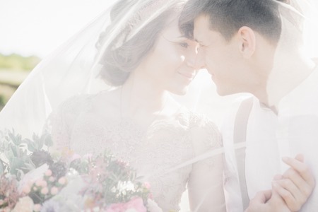 wedding couple on  nature.  bride and groom hugging under the veil at  wedding.の写真素材