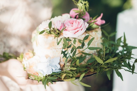 bride holding wedding cake. wedding cake decorated with flowersの写真素材