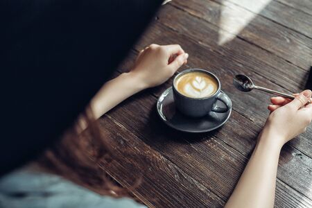 Woman in hat with cup of fragrant coffee with foam. top viewの写真素材