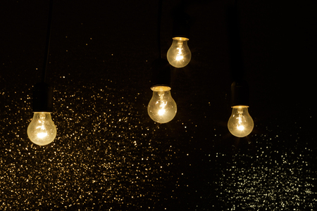 light bulbs on a black background with sparklesの写真素材